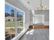 Spacious living room showcasing large windows with views of the landscape and an elegant chandelier at 1685 Great Oaks Dr, Lawrenceville, GA 30045