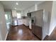 This bright kitchen features white cabinets, stainless steel appliances, quartz countertops, and wood floors at 2127 Whites Mill Rd, Decatur, GA 30032