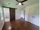 Bedroom with wood floors, a ceiling fan, a sliding barn door to the bathroom, and closet space at 2127 Whites Mill Rd, Decatur, GA 30032