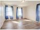 Bright bedroom featuring gleaming wood floors and three windows dressed with sheer curtains at 5136 Jones Rd, Forest Park, GA 30297