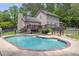 Backyard featuring a pool, deck, fence, and lush green landscaping at 955 Chandler Haulk Rd, Loganville, GA 30052