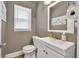 Cozy bathroom with white vanity, toilet, and window with blinds at 955 Chandler Haulk Rd, Loganville, GA 30052