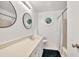 Bathroom with a long vanity, round mirrors, an octagonal window, and a shower at 955 Chandler Haulk Rd, Loganville, GA 30052