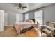 Cozy bedroom featuring a ceiling fan, natural light from two windows, and a comfortable accent chair at 955 Chandler Haulk Rd, Loganville, GA 30052