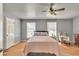 Bedroom with light grey walls, ceiling fan, area rug, and two windows overlooking the exterior at 955 Chandler Haulk Rd, Loganville, GA 30052