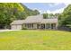 Charming single-Gathering home featuring a large manicured lawn, a covered porch with rocking chairs, and an attached two-car garage at 955 Chandler Haulk Rd, Loganville, GA 30052