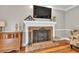 Close up of the fireplace with a decorative mantel, brick surround, and a vintage-style screen at 955 Chandler Haulk Rd, Loganville, GA 30052