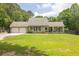 Beautiful single-Gathering home with a two-car garage, lush green lawn, and inviting covered front porch with rocking chairs at 955 Chandler Haulk Rd, Loganville, GA 30052
