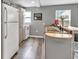 Bright and tidy kitchen with plank floors, white appliances, and a sink with a view to the living room at 955 Chandler Haulk Rd, Loganville, GA 30052