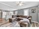 Bright living room featuring an open layout with plank floors, recessed lighting, and a large leather sectional couch at 955 Chandler Haulk Rd, Loganville, GA 30052