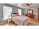 Well-lit primary bedroom featuring neutral gray walls, hardwood floors, and traditional furniture at 955 Chandler Haulk Rd, Loganville, GA 30052
