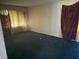 Empty living room with large windows, curtains, and dark blue carpeting ready to be refreshed at 1275 Bell Ave, Atlanta, GA 30344