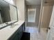 Bright bathroom featuring tiled floors, a modern vanity, and combined shower and tub at 2550 Kentshire Way, Lawrenceville, GA 30044