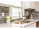 Granite countertops, stainless steel sink, gray brick backsplash, and white cabinets in this kitchen at 272 Old Sudie Rd, Hiram, GA 30141