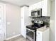 Updated kitchen features stainless steel appliances, white cabinets, and a light gray backsplash at 272 Old Sudie Rd, Hiram, GA 30141