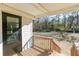 View of porch with black door and wooden railing overlooking a large, grassy backyard at 272 Old Sudie Rd, Hiram, GA 30141