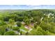An aerial view of a quaint home surrounded by lush greenery and mature trees with a mountain view at 4605 Tims Pl, Snellville, GA 30039