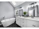 Bright bathroom featuring a standalone tub, double vanity, modern fixtures, and black hexagon tile floors at 4605 Tims Pl, Snellville, GA 30039