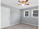 This bedroom features a ceiling fan, two windows with blinds, and neutral carpet at 4605 Tims Pl, Snellville, GA 30039