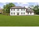 Elegant two-story white brick home with a lush green lawn and mature trees at 4605 Tims Pl, Snellville, GA 30039