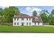 Classic two-story white home with well-manicured front yard and dark roof in a suburban setting at 4605 Tims Pl, Snellville, GA 30039