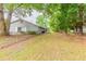 A grassy backyard surrounded by trees and a chain-link fence at 6715 Kimberly Mill Rd, Atlanta, GA 30349