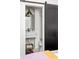 Modern bathroom featuring a sliding barn door, marble vanity, and toilet with towel storage at 135 Mado Ln, Chattahoochee Hills, GA 30268