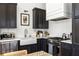 Modern kitchen featuring stainless steel appliances, dark cabinets, and white subway tile backsplash at 135 Mado Ln, Chattahoochee Hills, GA 30268