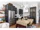Modern kitchen featuring stainless steel appliances, dark cabinets, and open dining area at 135 Mado Ln, Chattahoochee Hills, GA 30268