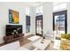Modern living room with stylish decor, a TV, large windows, and hardwood floors at 135 Mado Ln, Chattahoochee Hills, GA 30268