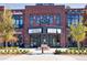 Brick building exterior with retail spaces and visible movie schedule, showcasing a vibrant urban community at 2255 Windsor Bluffs Dr, Cumming, GA 30041