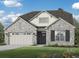 Beautiful single-Gathering home with gray brick, complemented by a lush lawn and charming landscaping at 2255 Windsor Bluffs Dr, Cumming, GA 30041