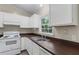 Well-lit kitchen featuring white appliances, cabinets, and sink with wood tone counter at 354 Henry Aaron Sw Ave, Atlanta, GA 30310