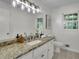 Bright bathroom featuring a granite countertop, white cabinets, and a mirrored vanity at 5400 Mill Run Dr, Marietta, GA 30068