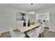 Dining room with modern light fixture, wood table, and decor; flows into sunlit living area at 5400 Mill Run Dr, Marietta, GA 30068