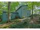 Charming exterior view of the blue two-story home surrounded by mature trees and lush landscaping at 5400 Mill Run Dr, Marietta, GA 30068
