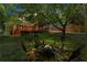 Tranquil backyard at dusk featuring a fire pit, green lawn, covered porch, and deck at 1734 8Th St, Atlanta, GA 30341