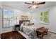 Inviting bedroom features plush bedding, a ceiling fan, hardwood floors, and natural light from two windows at 1734 8Th St, Atlanta, GA 30341