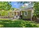 Charming single-story home with green siding, a landscaped front yard, and inviting front porch with bench seating at 1734 8Th St, Atlanta, GA 30341