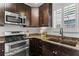 Well-lit kitchen features stainless steel appliances, dark wood cabinets, and granite countertops at 1734 8Th St, Atlanta, GA 30341