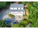 Aerial view of a charming home with a large driveway and surrounded by lush greenery and mature trees at 2024 Lower Burris Road Rd, Canton, GA 30114