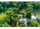 Aerial view of a wooded property featuring a home, outbuildings, and an above-ground pool at 2024 Lower Burris Road Rd, Canton, GA 30114
