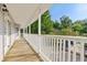 Long, covered deck with white railings, offering scenic views of the surrounding landscape at 2024 Lower Burris Road Rd, Canton, GA 30114