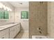 Bright bathroom showcasing a double vanity, updated tile in the shower, and ample natural light, for a fresh and modern appeal at 2041 Kramer Way, Marietta, GA 30062