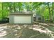 Charming home with a two-car garage and concrete driveway nestled among lush greenery and mature trees at 2041 Kramer Way, Marietta, GA 30062