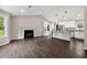 Spacious living room with dark wood floors, a fireplace, and a modern kitchen with white cabinets at 2872 Estuary Dr, Acworth, GA 30101