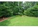 Large grassy backyard surrounded by mature trees and landscaping at 3361 Woodington Se Ct, Marietta, GA 30067