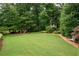 Expansive backyard featuring lush greenery, mature trees, and a charming treehouse at 3361 Woodington Se Ct, Marietta, GA 30067