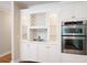 Custom kitchen cabinetry features glass shelving, wine storage, and built in double ovens at 3361 Woodington Se Ct, Marietta, GA 30067