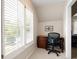 A quaint office nook features a desk, chair, and natural light from the shuttered window at 3361 Woodington Se Ct, Marietta, GA 30067
